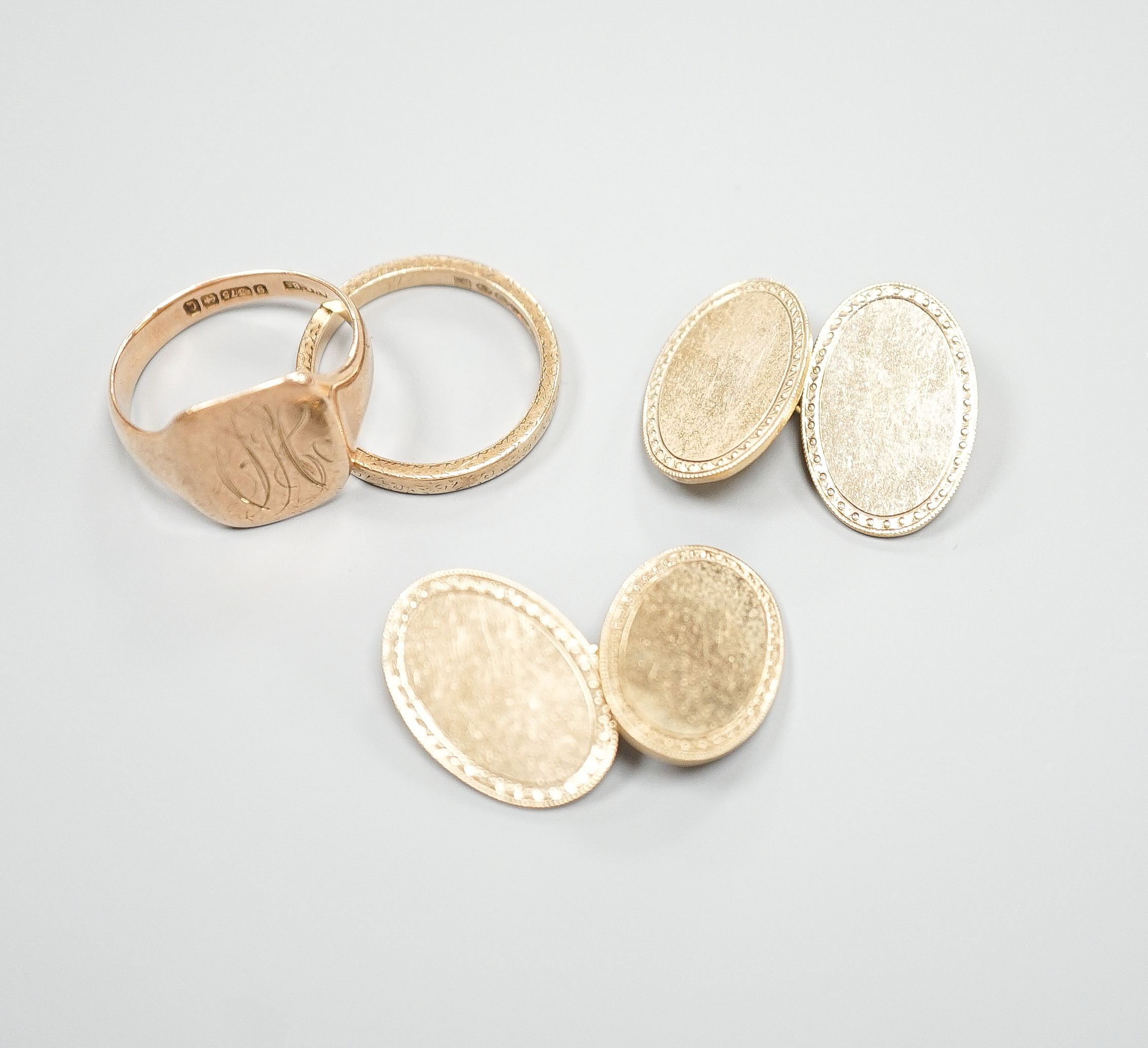 A 9ct gold wedding band, a 9ct gold signet ring and a pair of 9ct gold oval cufflinks